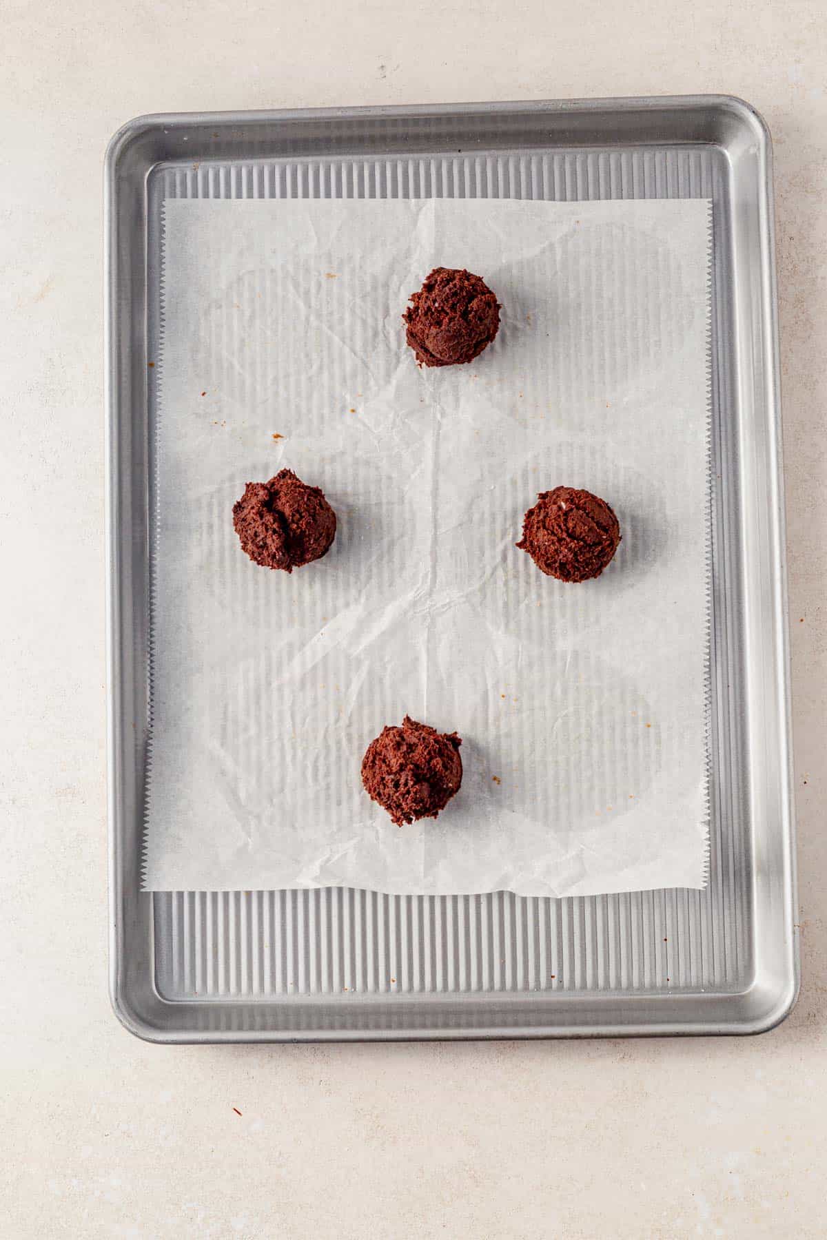 chocolate espresso martini cookie dough balls on a baking sheet.