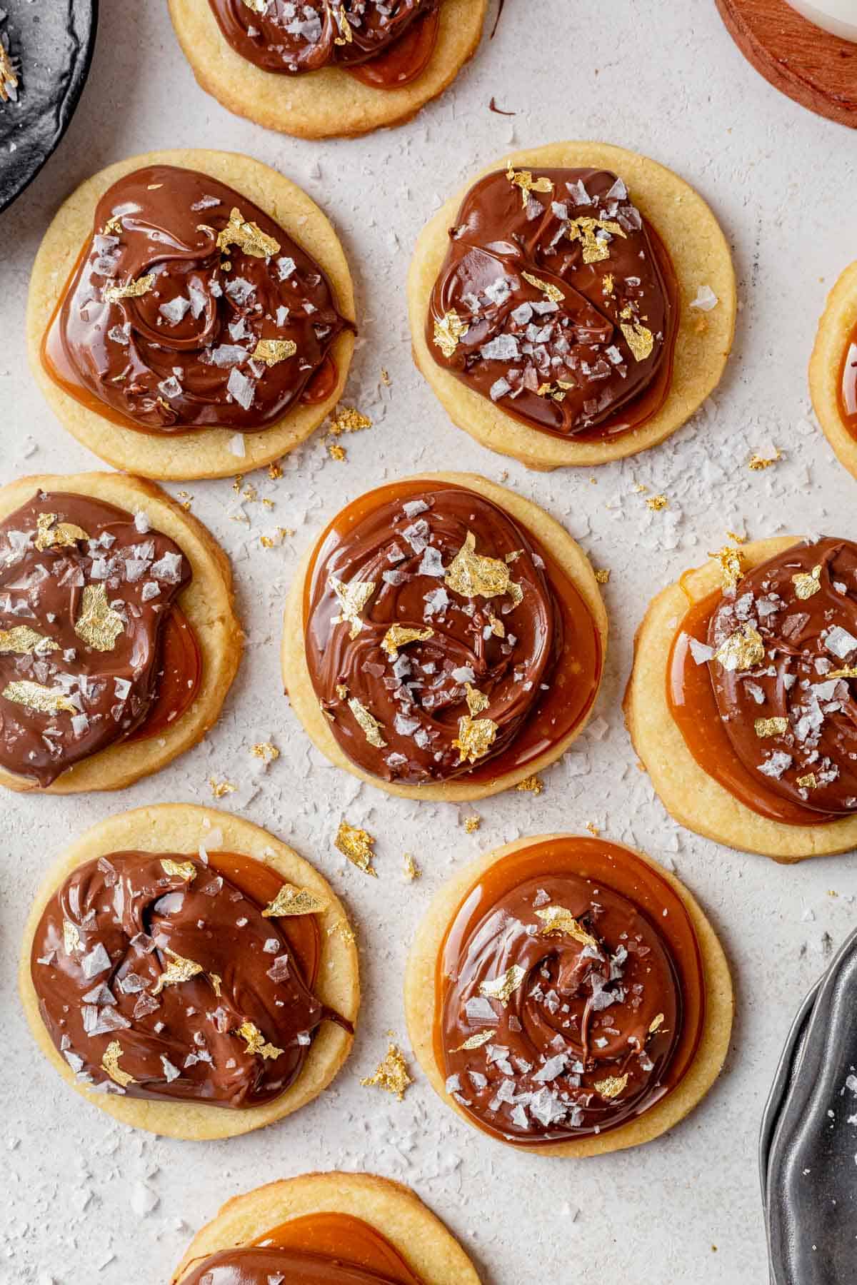 millionaire cookies decorated with gold leaf on a countertop.