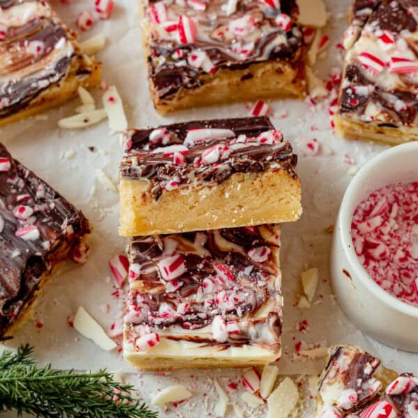 peppermint bark cookie bars cut into squares on a piece of parchment paper.