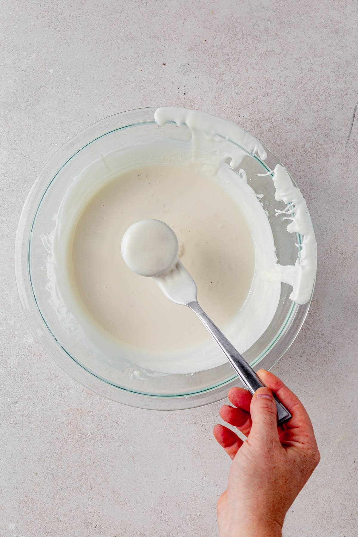 dipping an oreo in melted white chocolate.