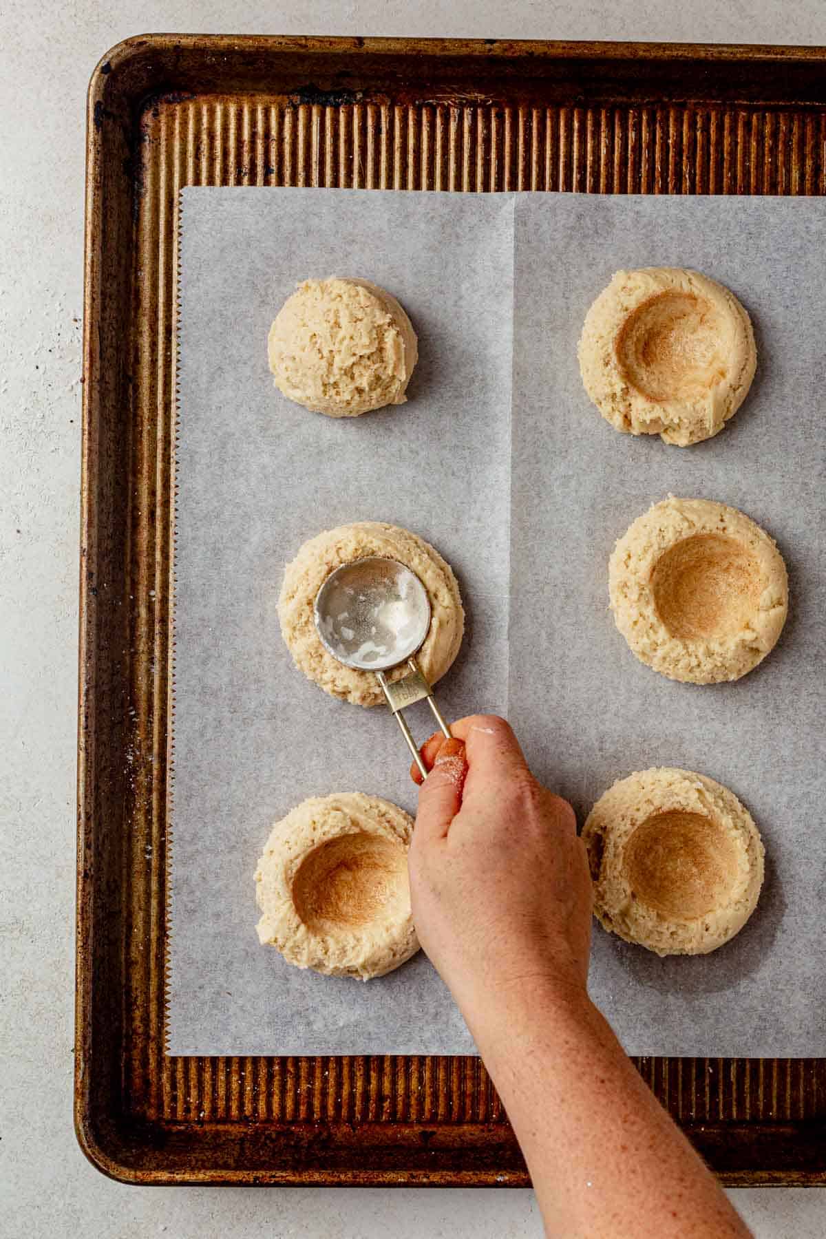 pressing a well into the center of a coffee cake cookie.