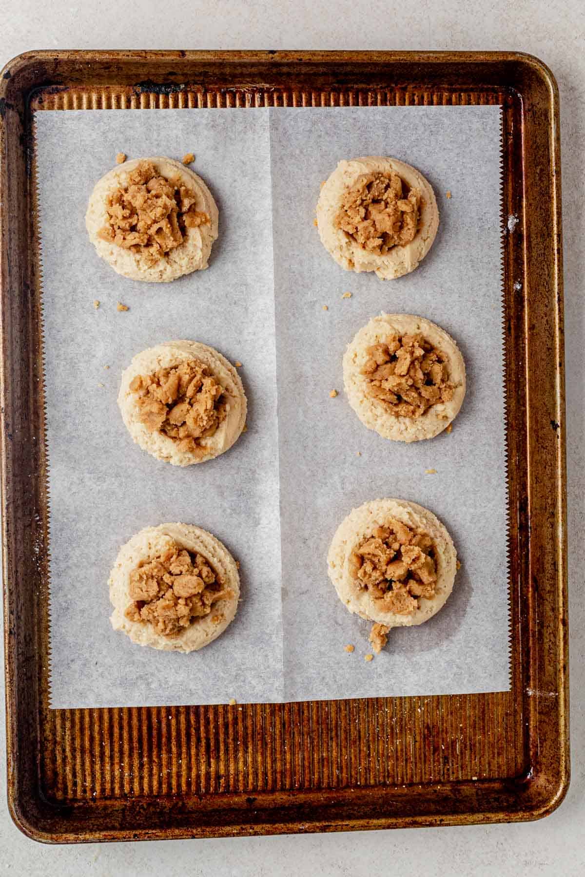 coffee cake cookies on a baking sheet with crumb topping before baking.