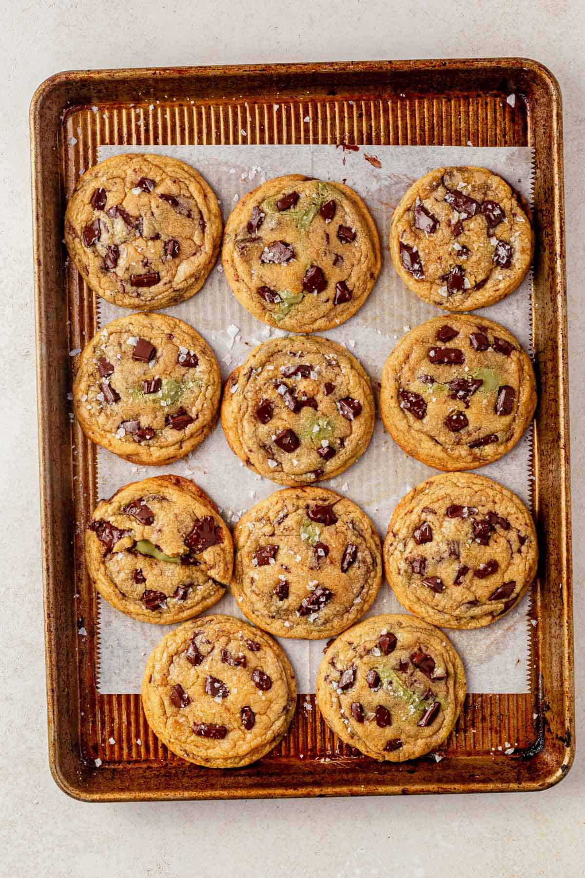 baked brown butter pistachio cookies cooling on a cookie sheet.