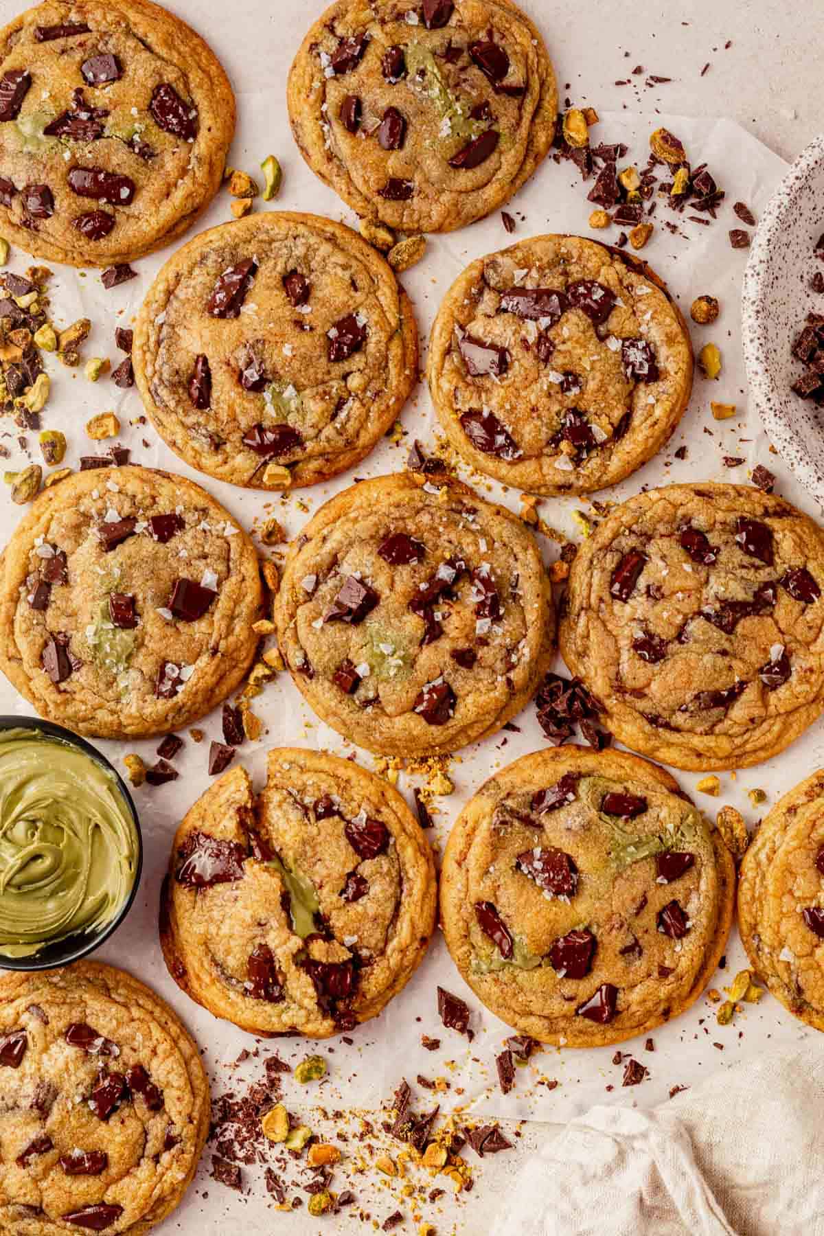 a batch of brown butter pistachio cookies on a piece of parchment paper.