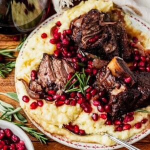 pomegranate short ribs and mashed potatoes on a plate.