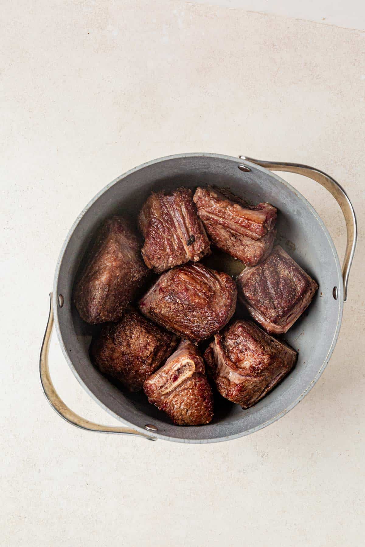 seared short ribs in a dutch oven.