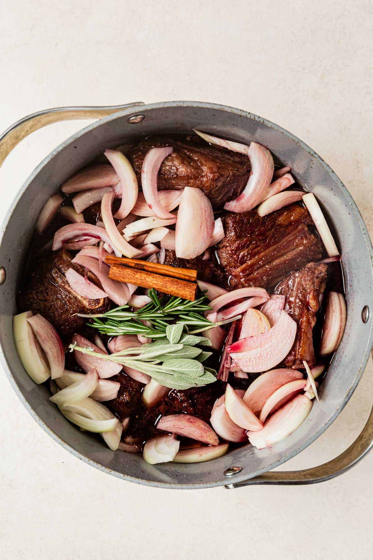 short ribs, pomegranate juice, onions, red wine, and herbs in a dutch oven.