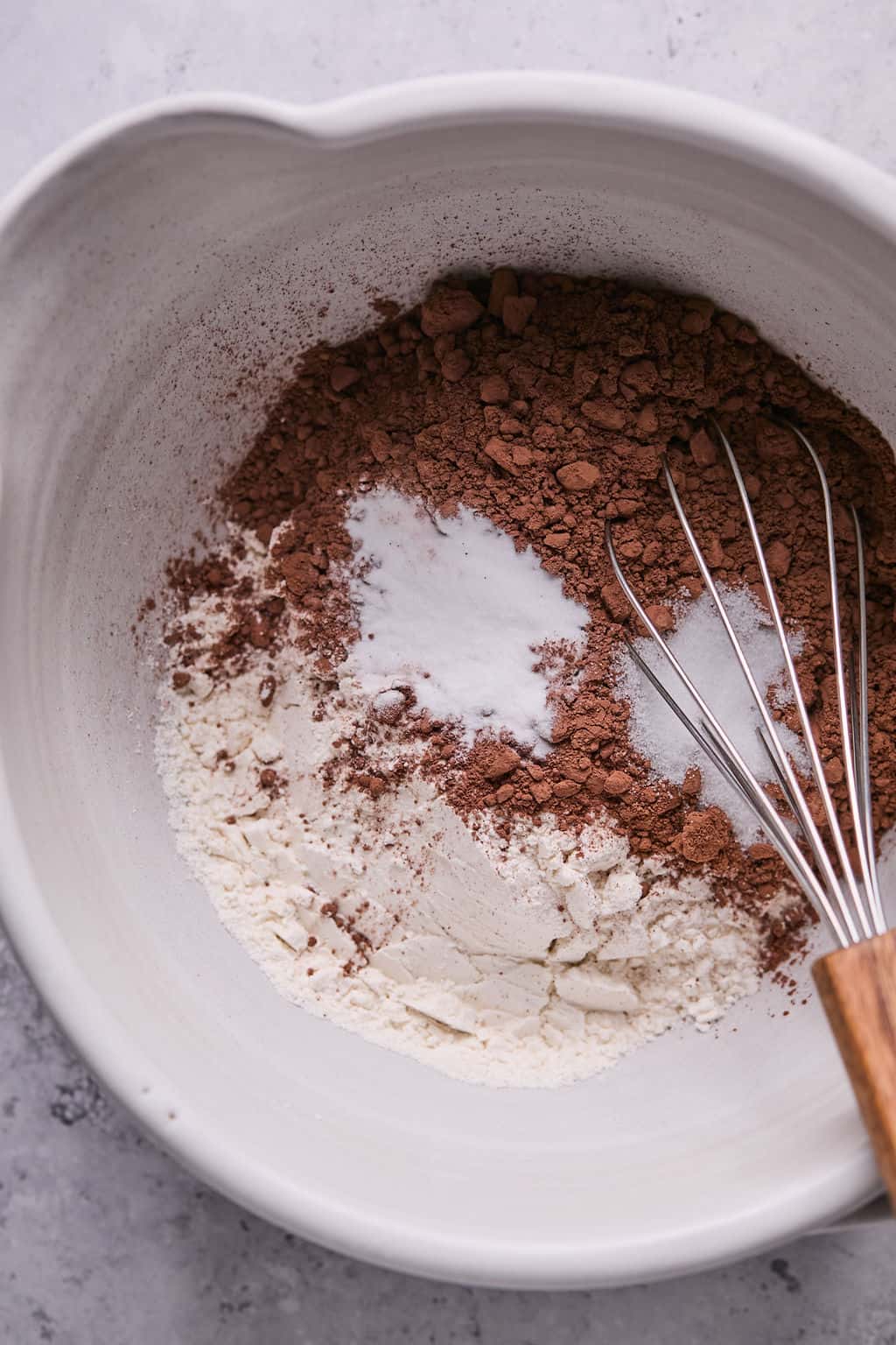 whisking cocoa powder, flour, salt, and baking soda in a bowl.