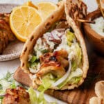 chicken gryo on a board with tzatziki and toppings.