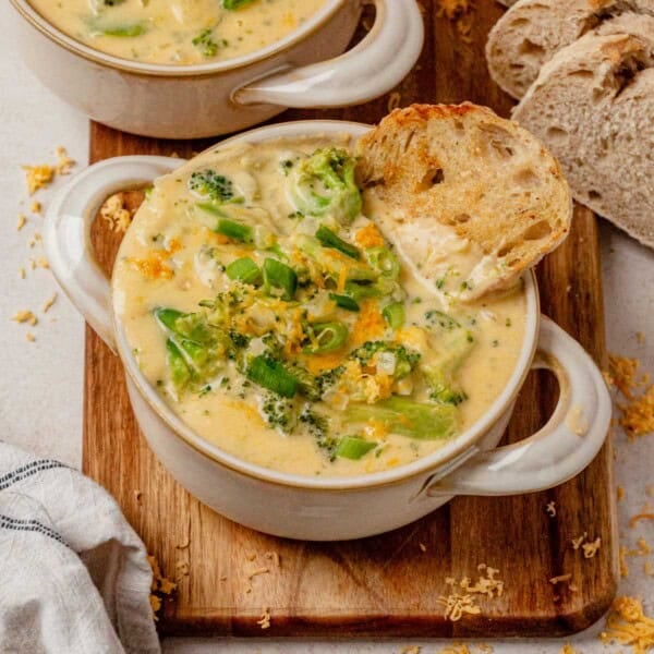 a bowl of broccoli cheddar soup with a piece of bread in it.