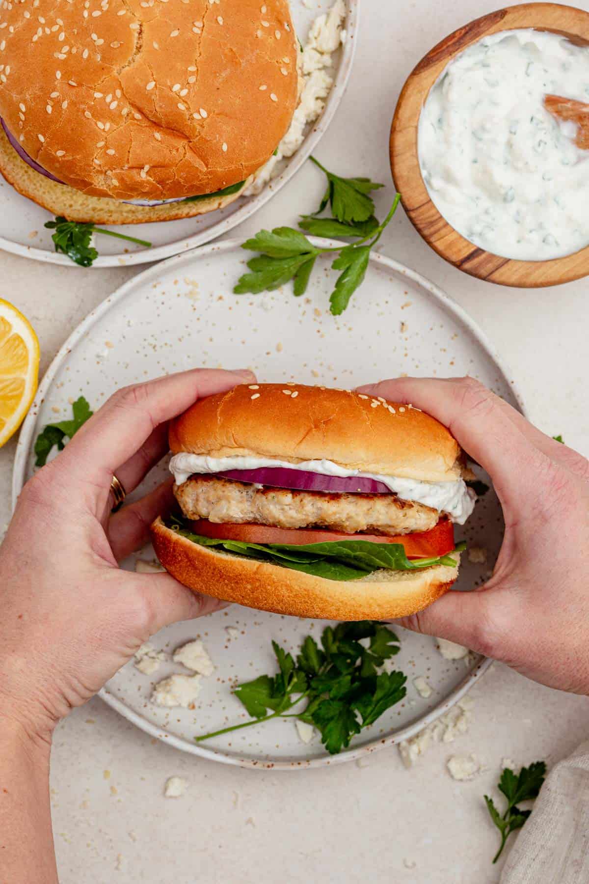 a chicken feta burger topped with spinach and tzaziki.