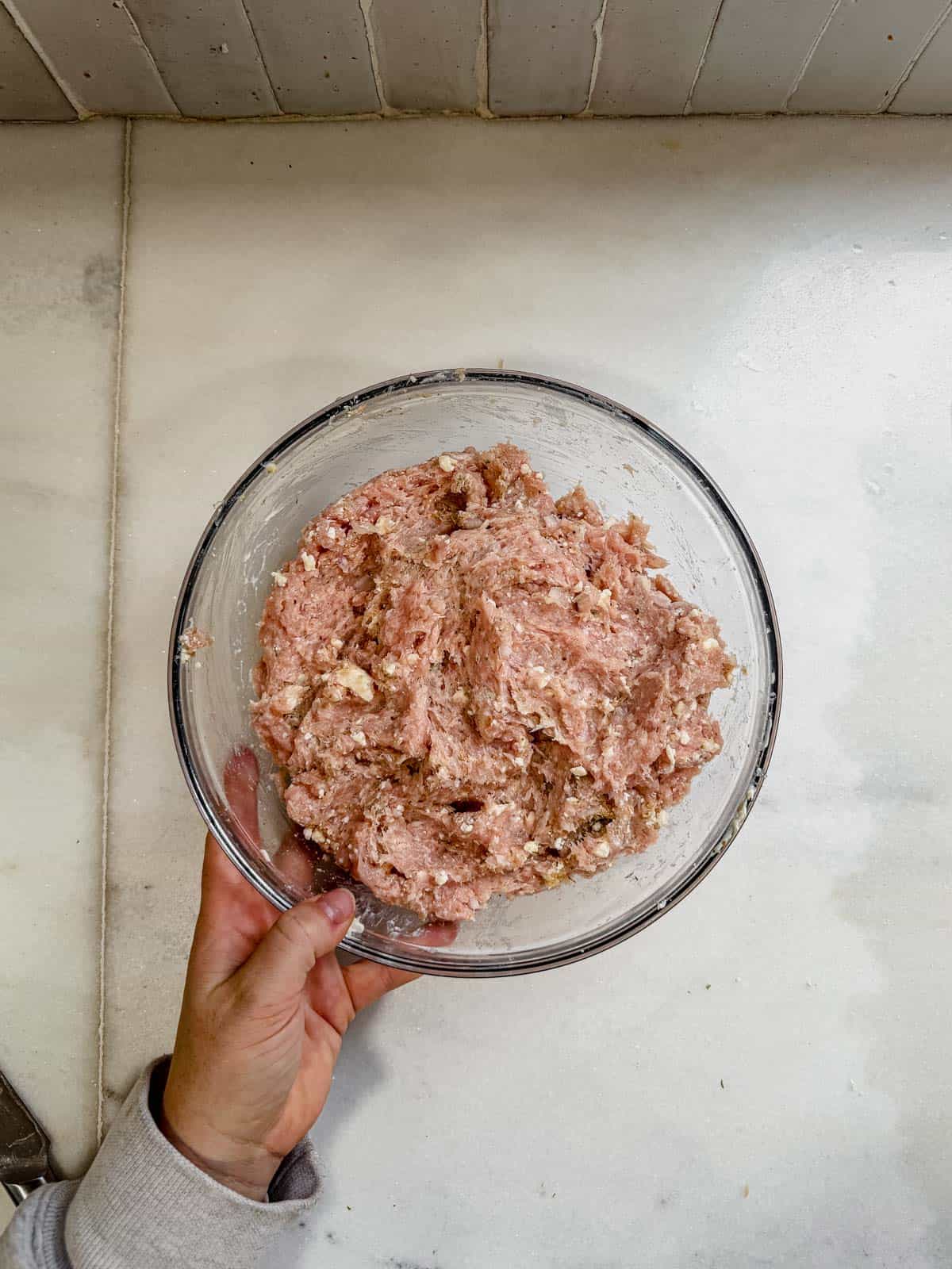 ground chicken and feta burger meat mixed in a bowl.