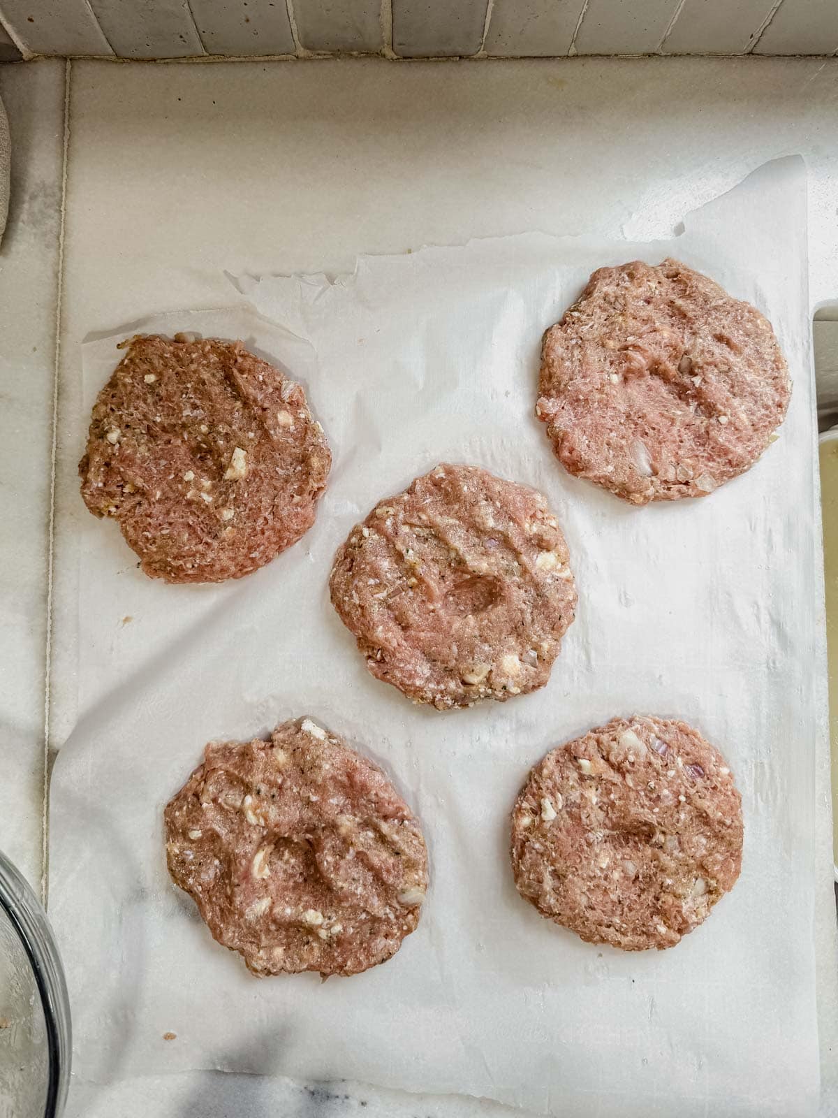 chicken and feta burgers formed into patties on a counter.