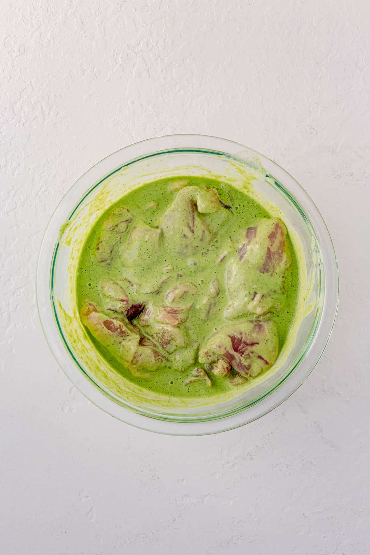 marinated green goddess chicken thighs in a bowl.