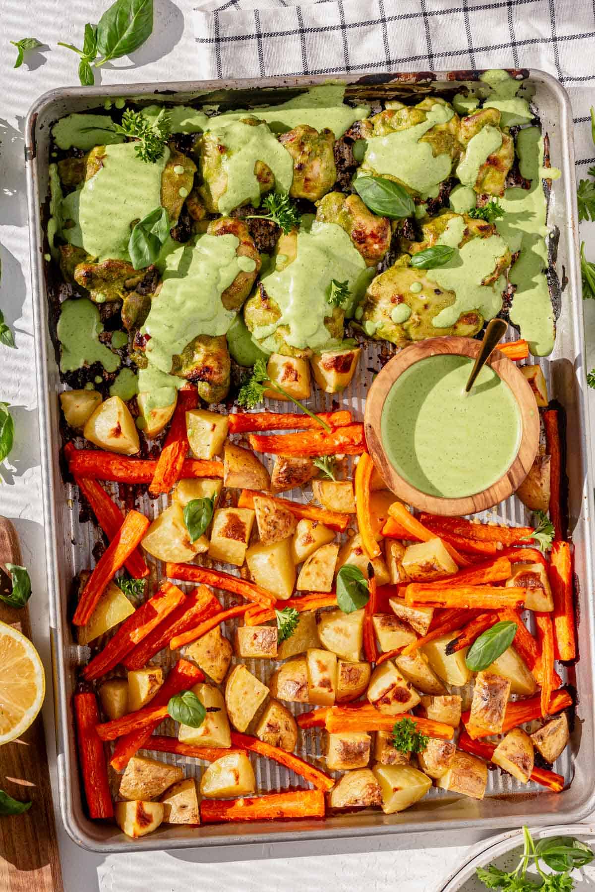 green goddess chicken on a sheet pan with roasted potatoes and carrots.