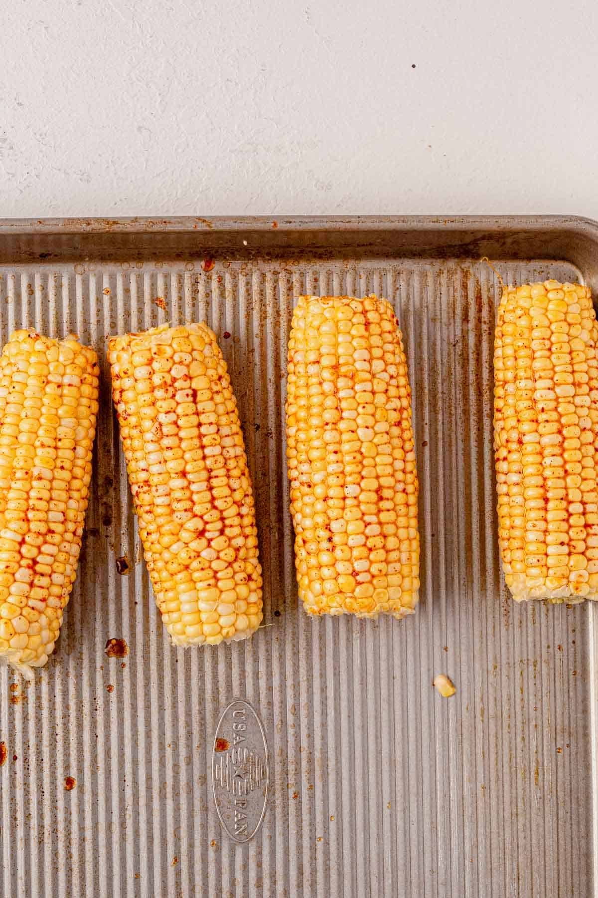 corn on the cob on a sheet pan.