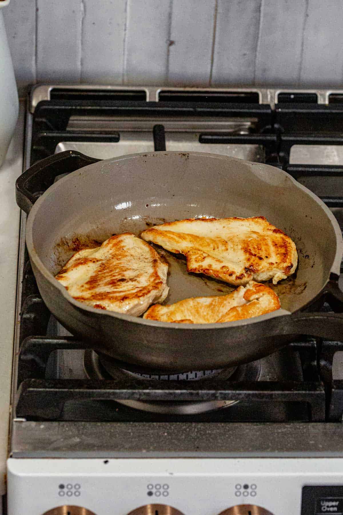 searing 3 chicken breasts in a skillet.