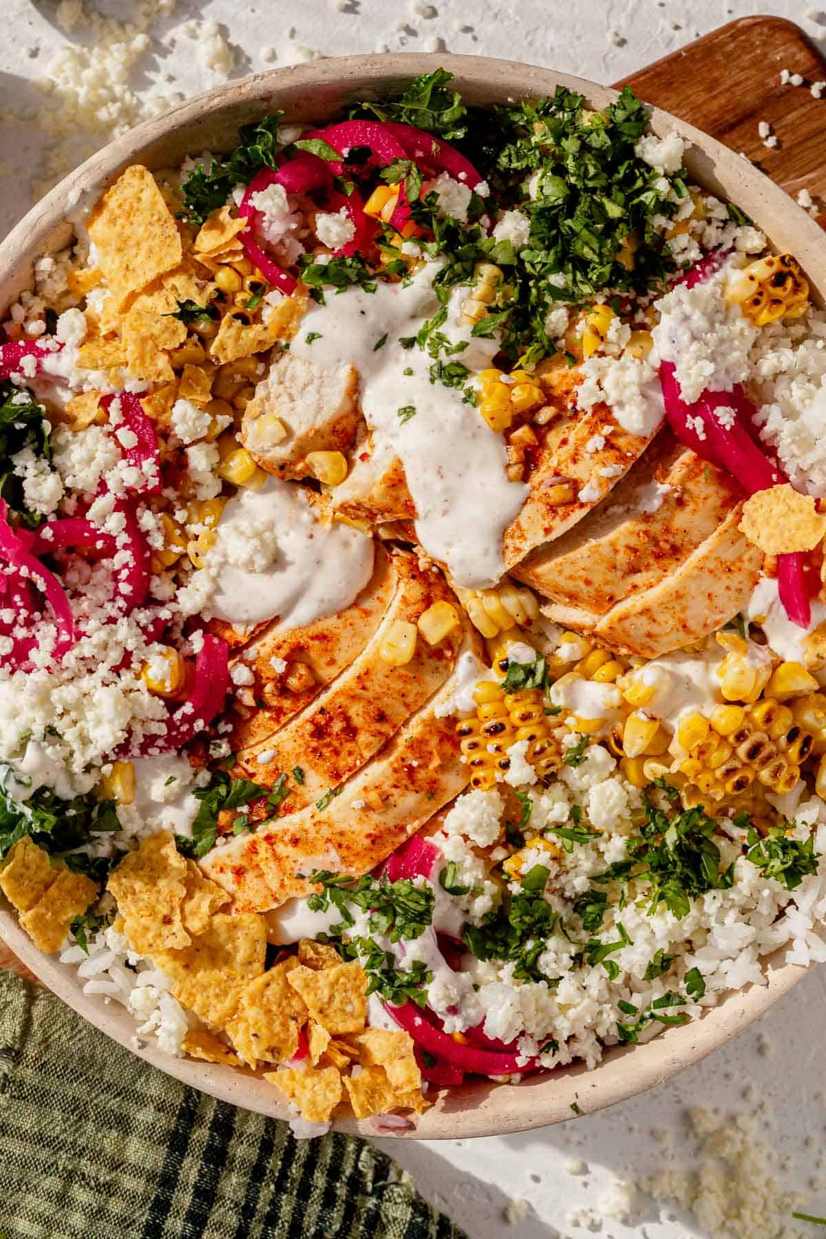 street corn rice bowl topped with creamy dressing on a counter.