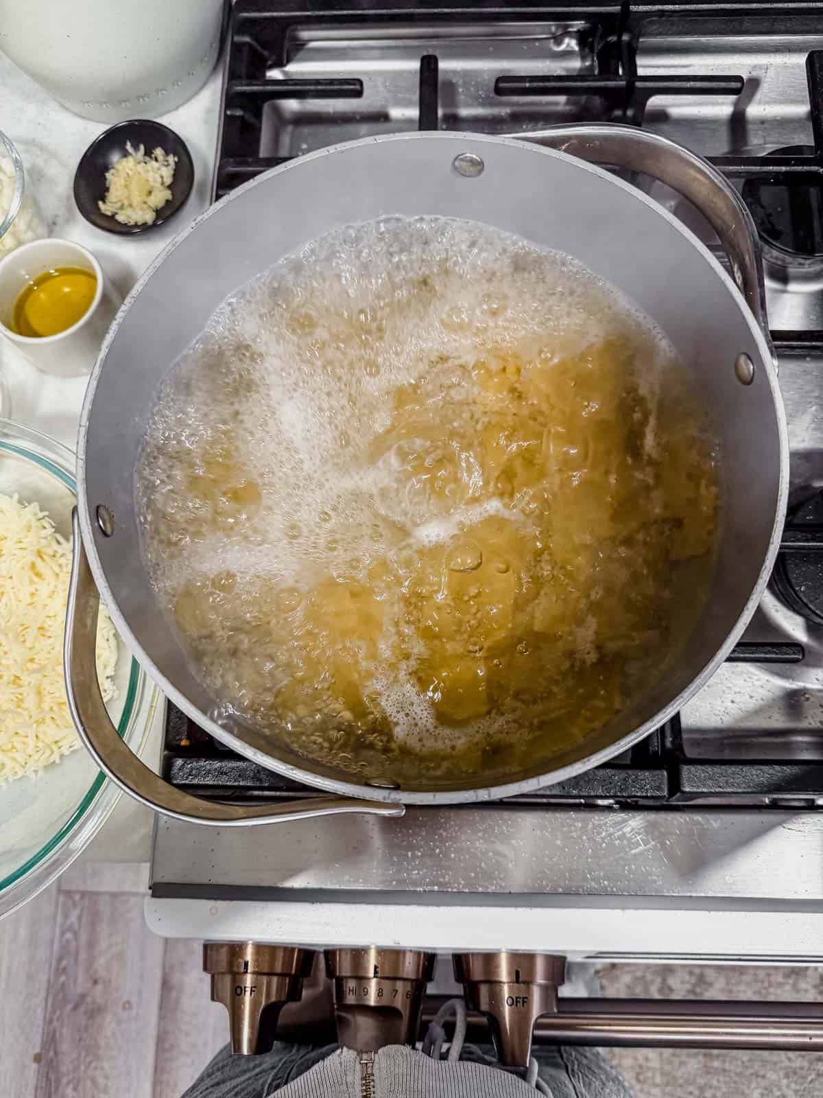 cooking lasagna noodles in a pot on the stove.