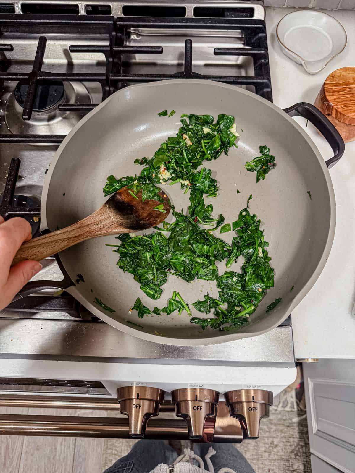 sauteeing spinach in a skillet.