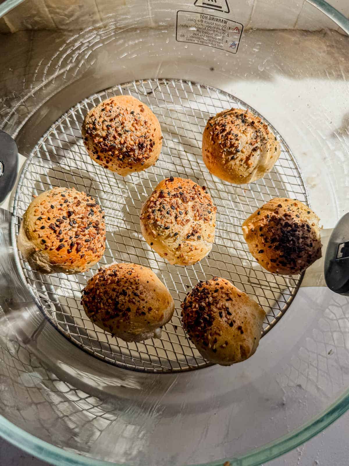 cream cheese stuffed bagel bites cooked in an air fryer basket.