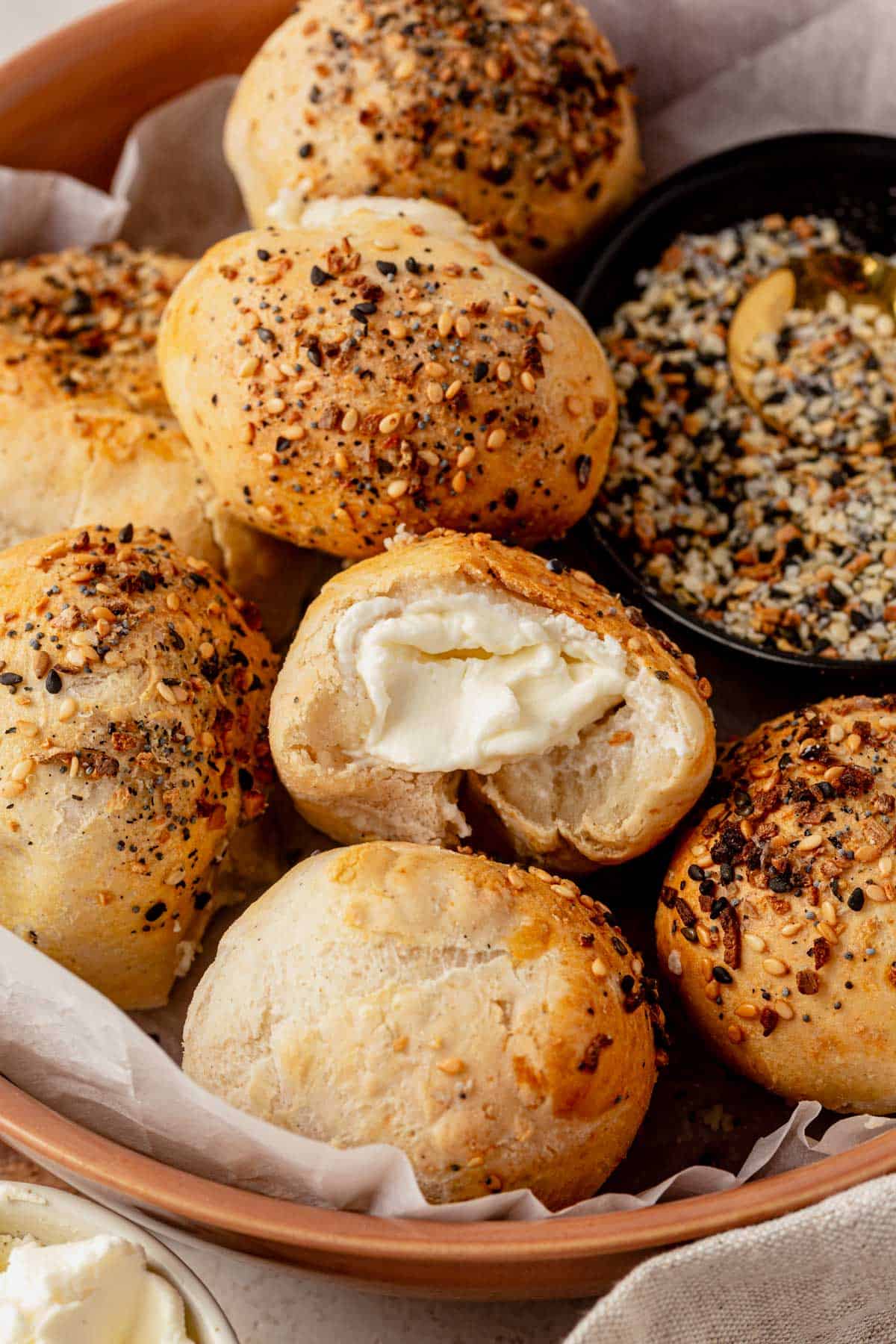 cream cheese stuffed bagel bites in a serving bowl with a bite missing from one.