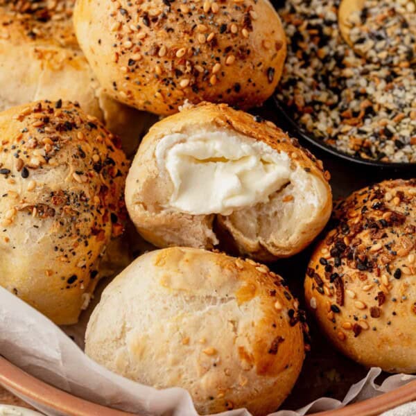 cream cheese stuffed bagel bites in a serving bowl with a bite missing from one.