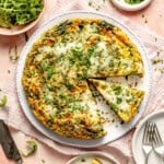 cooked vegetable frittata on a plate with a slice taken out