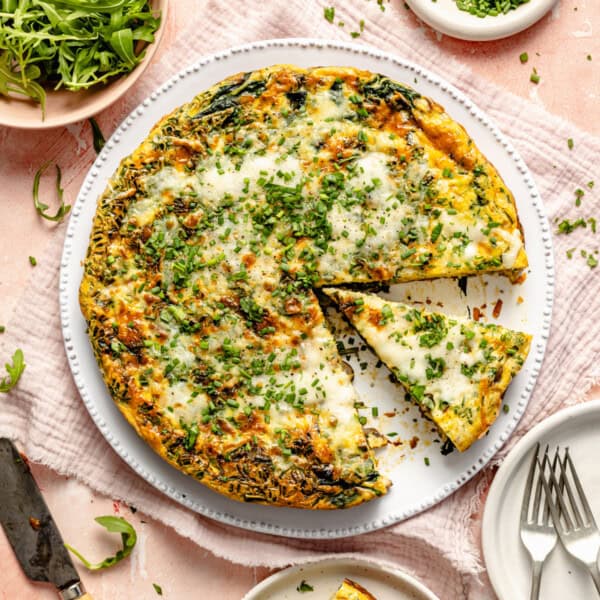 cooked vegetable frittata on a plate with a slice taken out