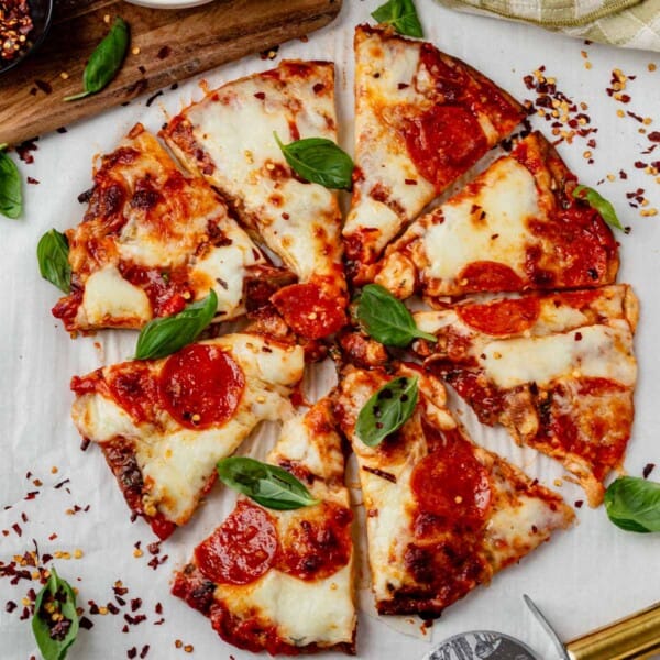 cottage cheese pizza crust with cheese and pepperoni sliced into pieces.