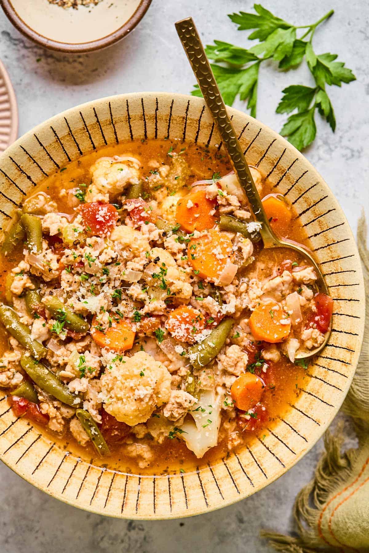 spoon dug into a bowl of low-carb turkey soup