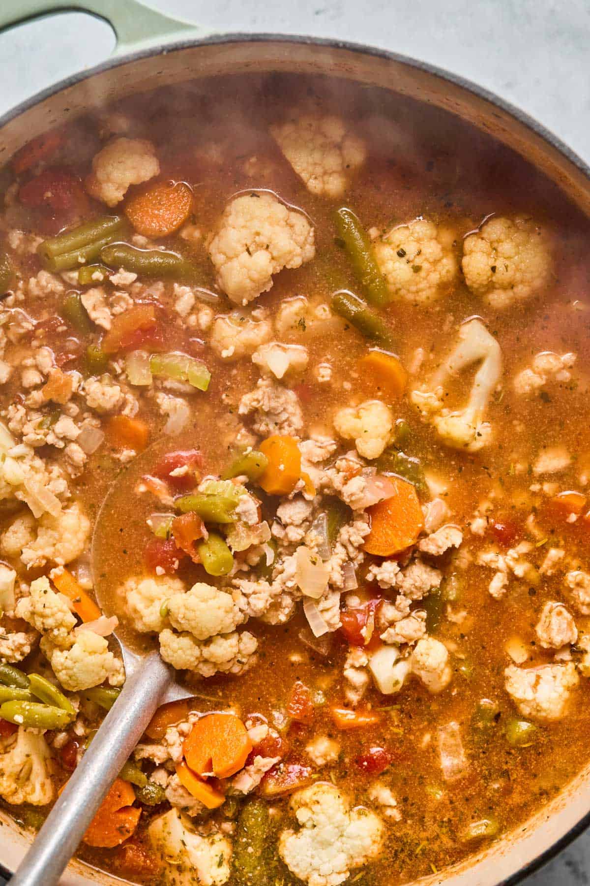 spoon stirring low-carb turkey soup