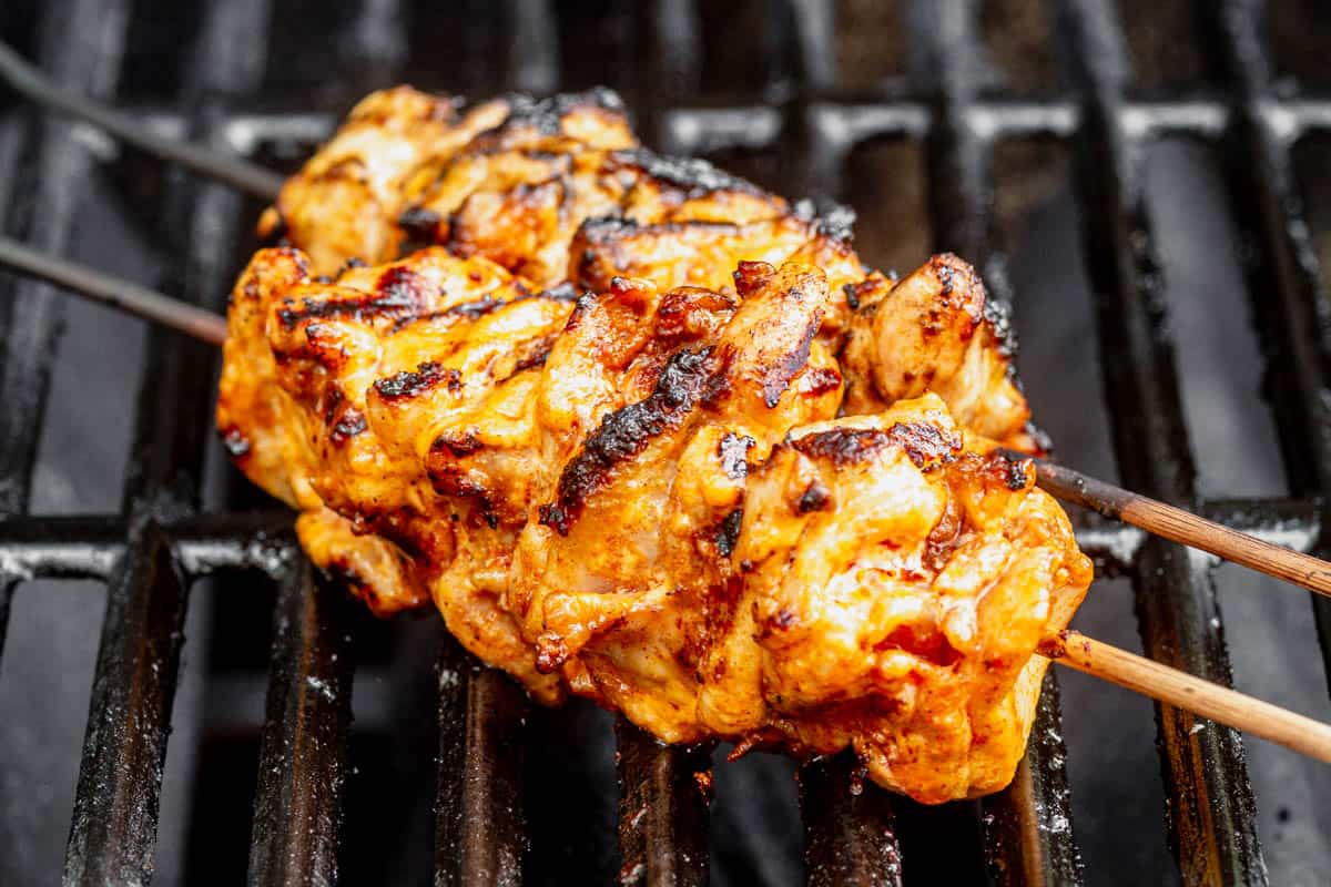 bang bang chicken skewers cooking on the grill.