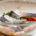 salmon fillets marinating in a lemon herb marinade.