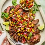 grilled flank steak and pineapple salsa served on a plate
