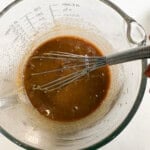 whisking pad thai sauce in a bowl.