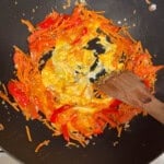 scrambling eggs in a wok with pad thai vegetables.