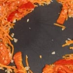 cooking bell pepper and carrots in a wok.