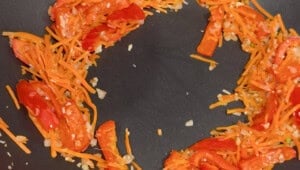 cooking bell pepper and carrots in a wok.