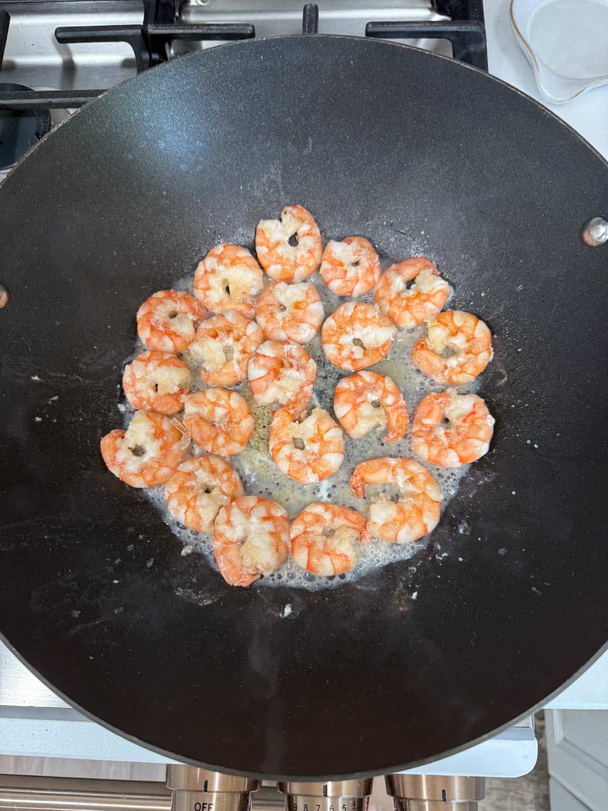 seared shrimp cooked in a wok.