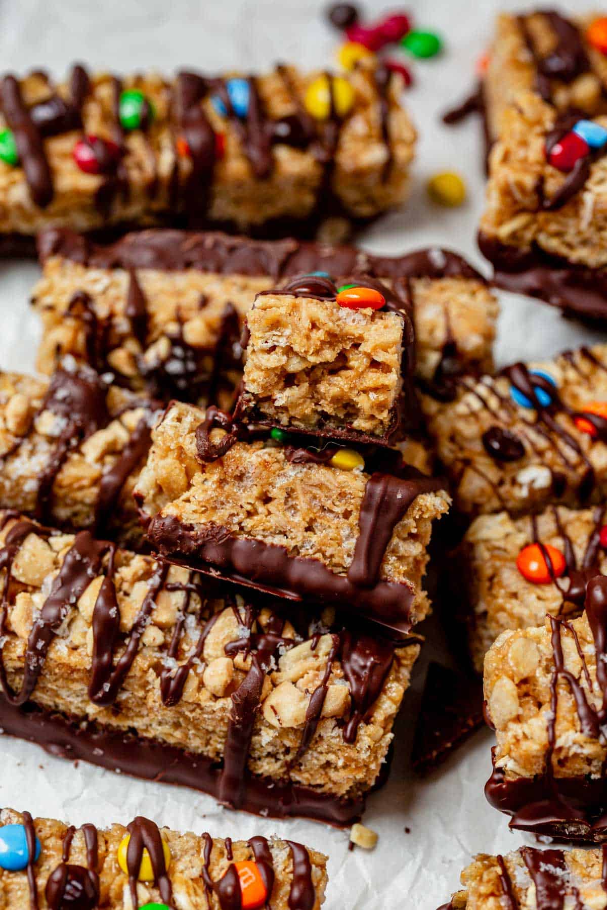 homemade kudos granola bar broken in half and stacked on top of a batch of bars.