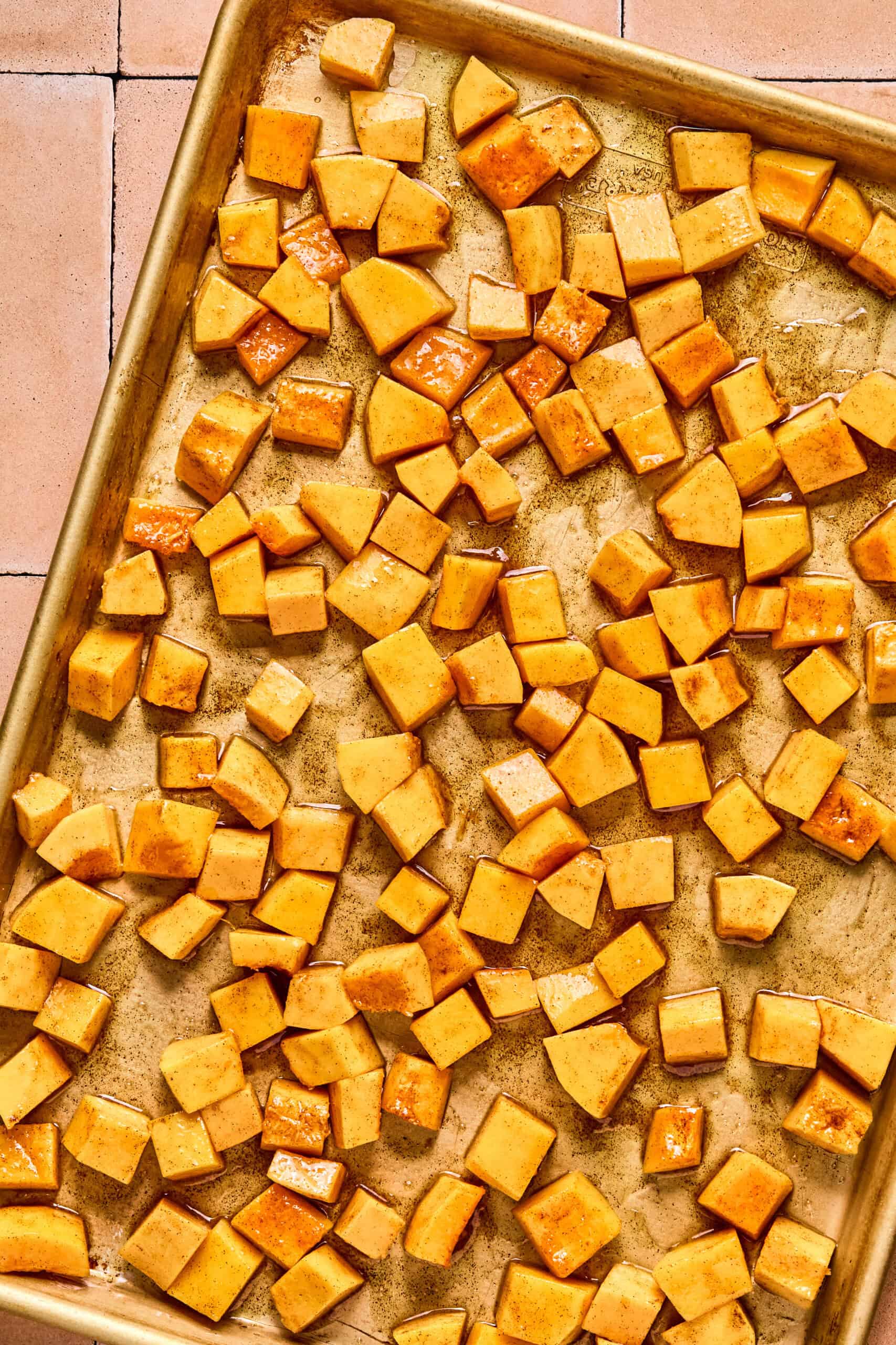 cubed butternut squash resting on a baking sheet ready to be roasted