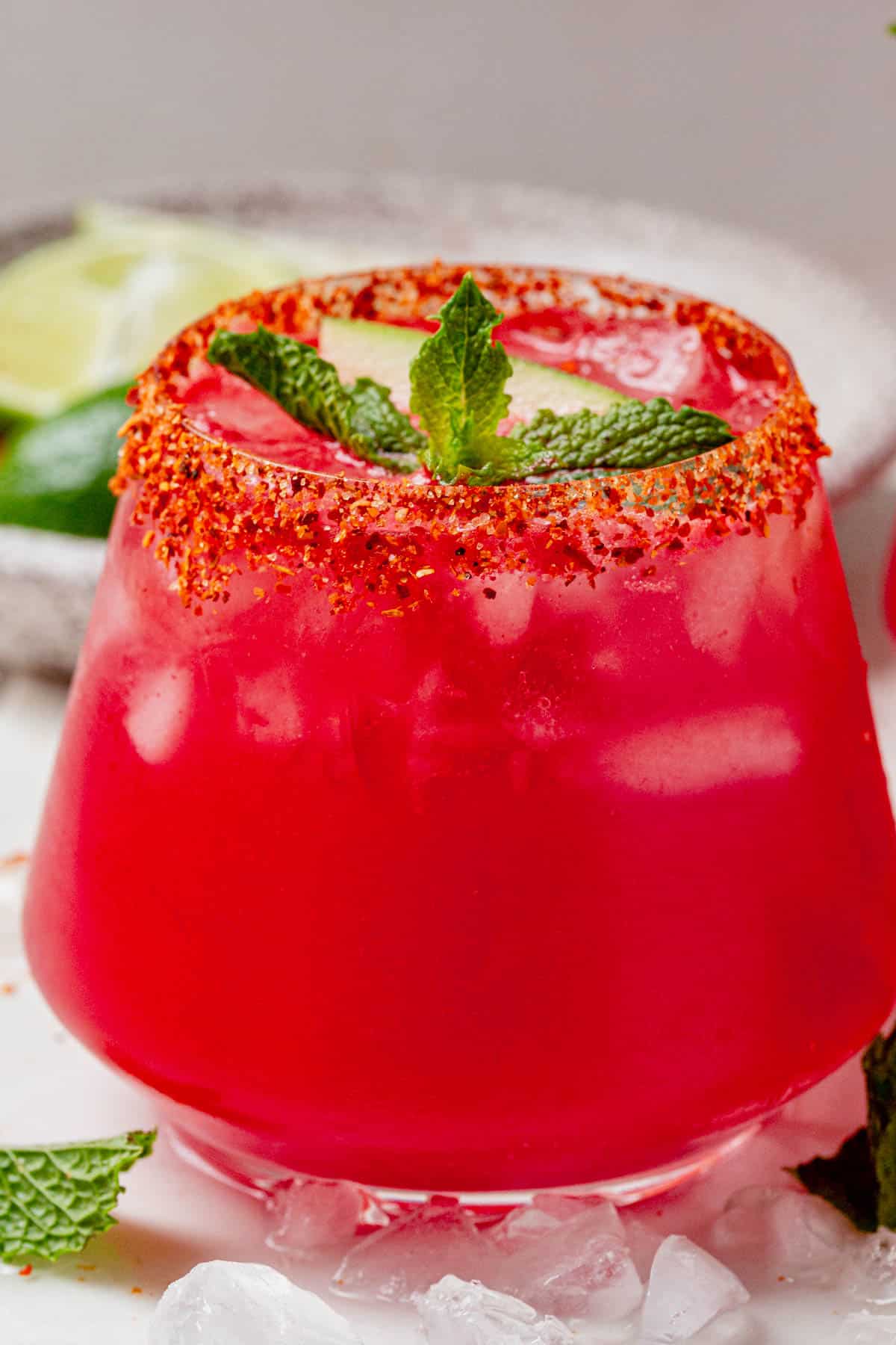 Straight-on view of a chilled watermelon vodka cocktail in a short glass, garnished with mint and lime.