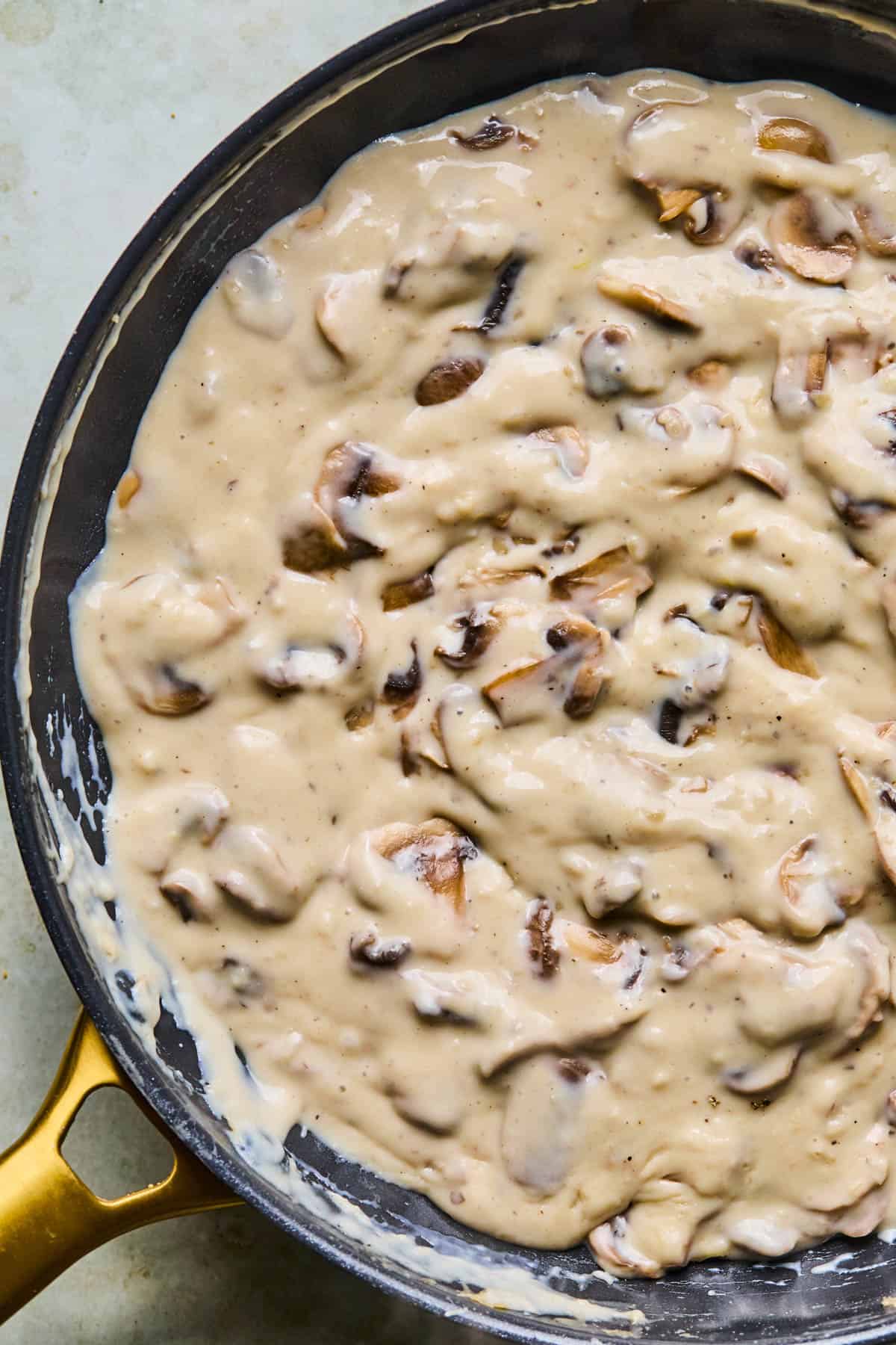 mushrooms for gluten-free dairy-free green bean casserole being cooked with vegan butter, gluten-free flour, broth, and dairy free milk.