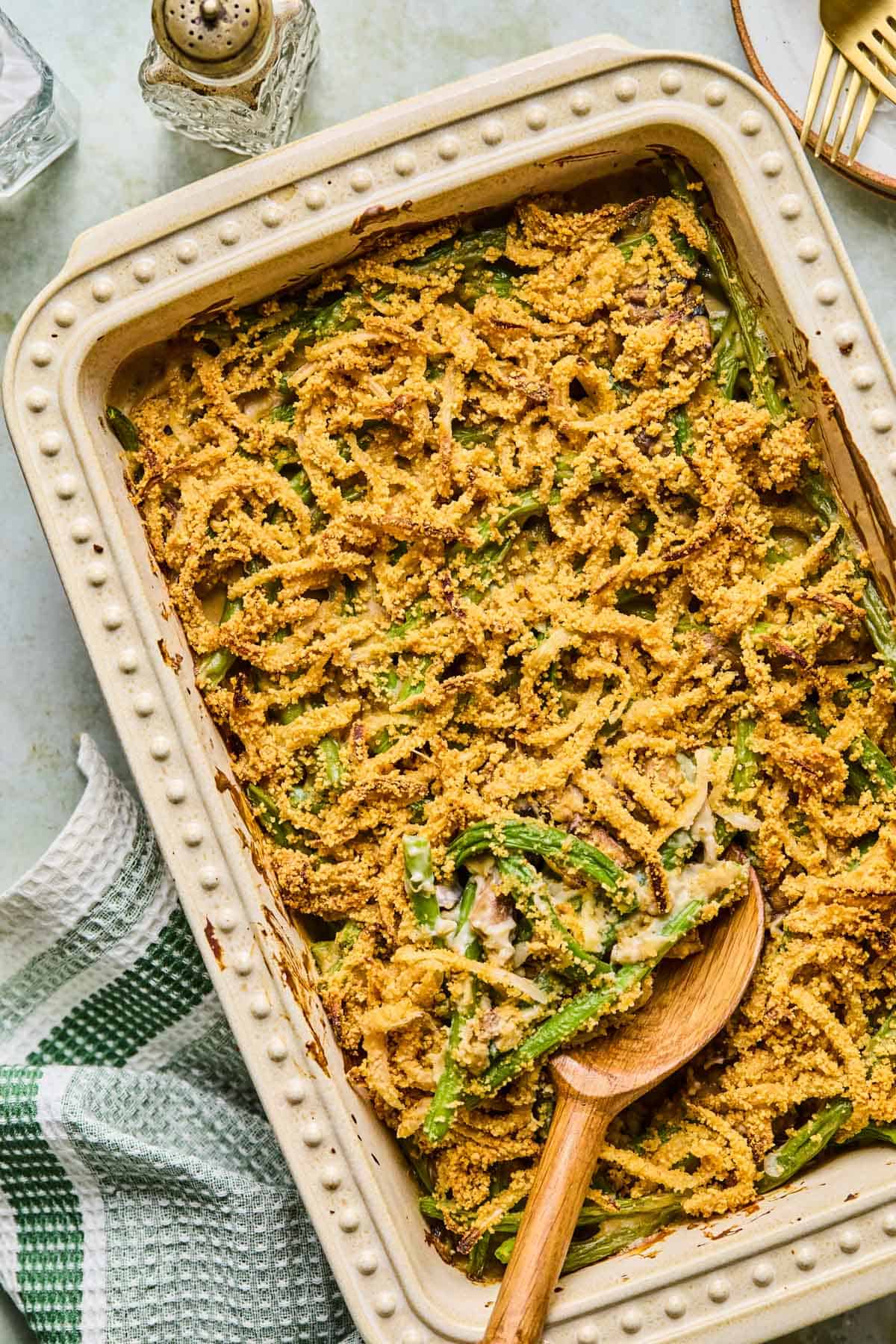 gluten free dairy free green bean casserole with a wooden spoon dug into it