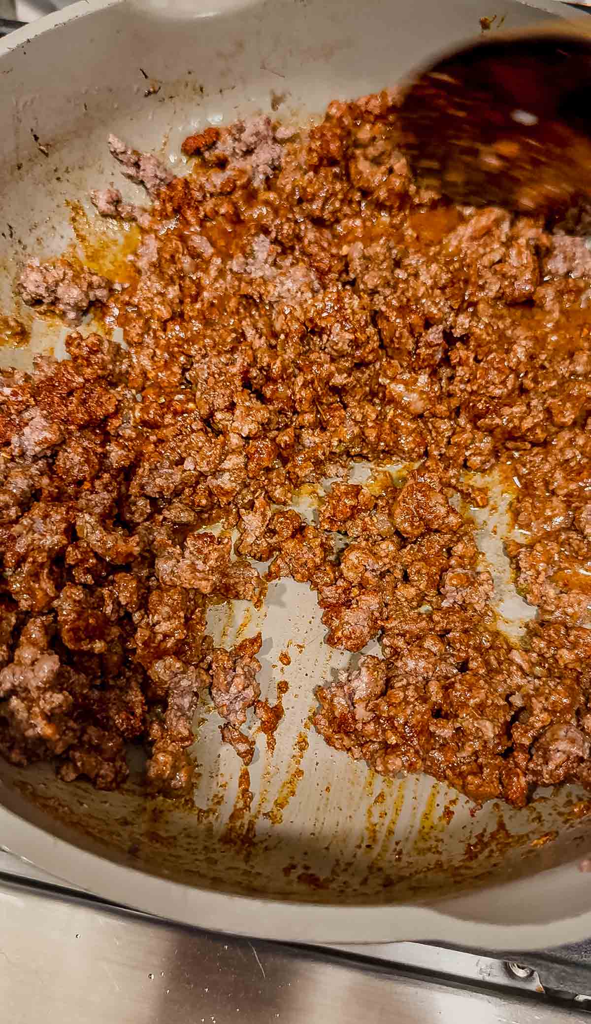 Cooking ground beef with taco seasoning in a skillet.