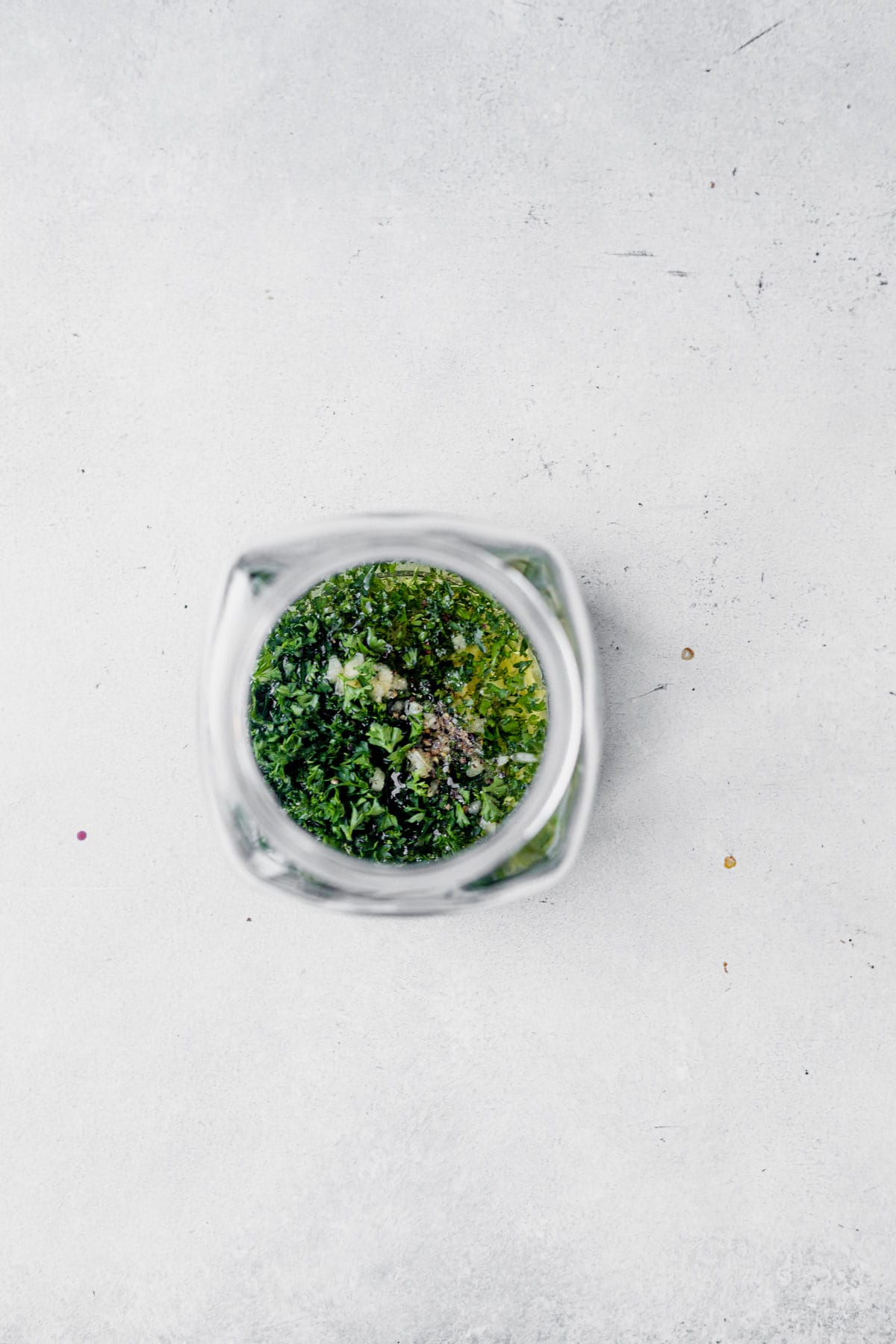 homemade parsley sauce in a glass jar on a white countertop