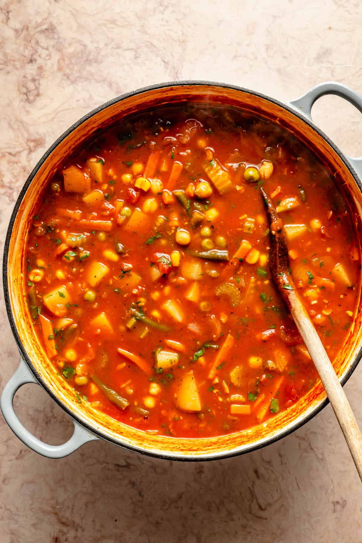 tomatoes, tomato sauce, potatoes, and frozen veggies added into crock of easy vegetable soup.