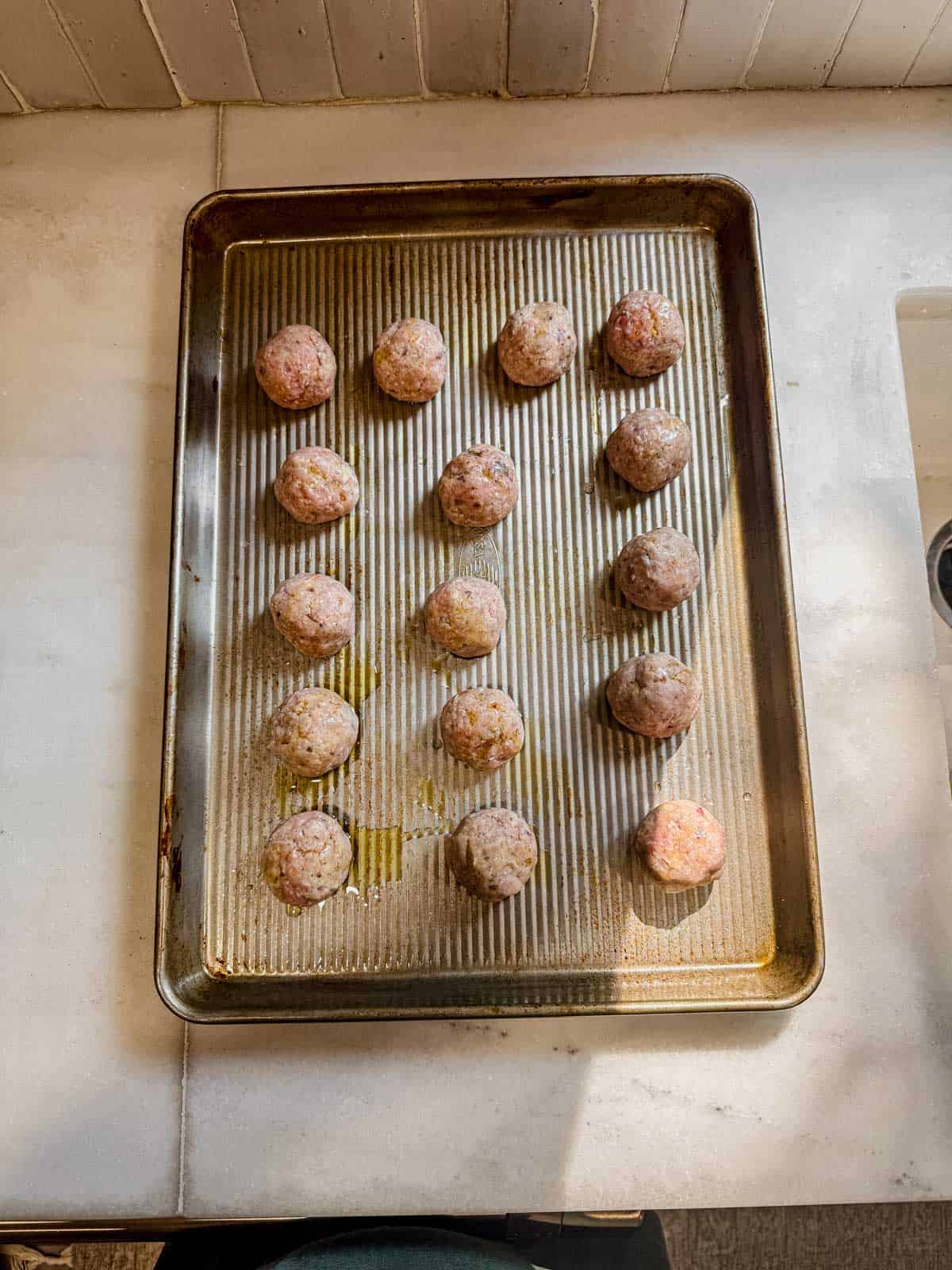 raw turkey meatballs arranged on a baking sheet.
