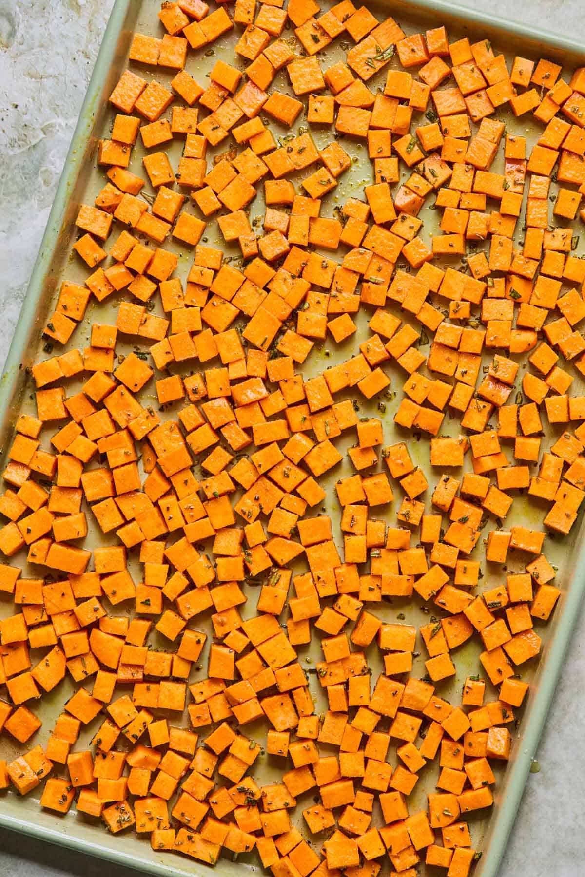 chopped sweet potato chunks coated in olive oil and seasoning and spread out into one single layer on a baking sheet.